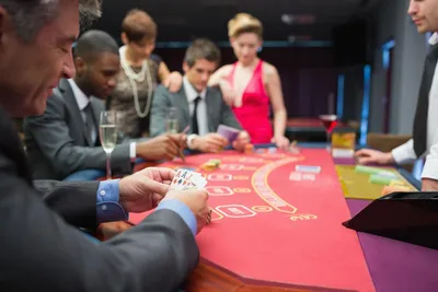 Group of friends play cards at fun casino party