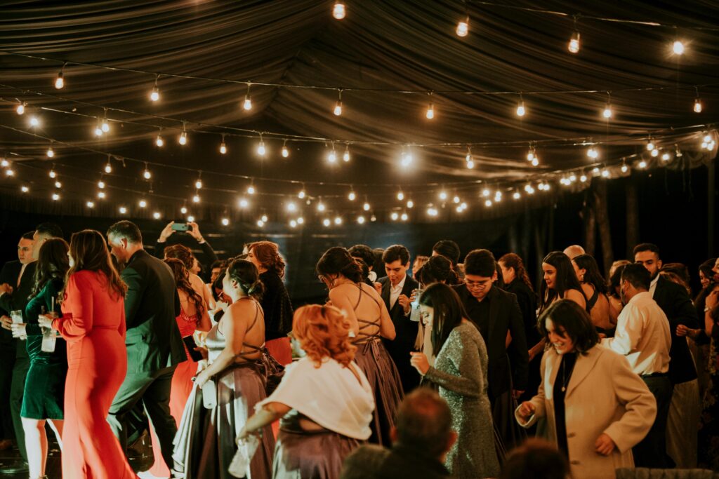 Guests enjoying an elegant evening wedding reception under string lights.