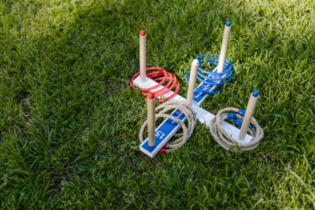 Vibrant ring toss game setup on a sunny day in a lush green park.